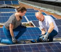 Im Bild ein Mann und eine Frau beim Praxisteil vom Photovoltaik-Lehrgang vom Bundesverband Photovoltaic Austria und TÜV Austria.