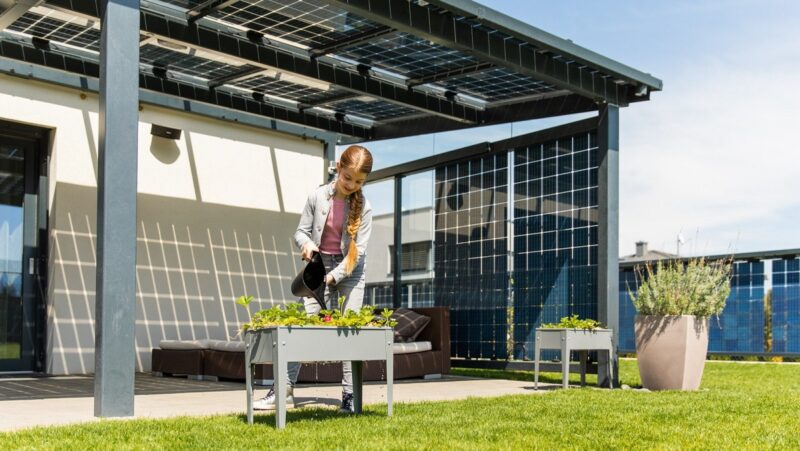 Ein Mädchen unter einer Solarüberdachung, der Photovoltaik-Zubau in Österreich ist gesunken.