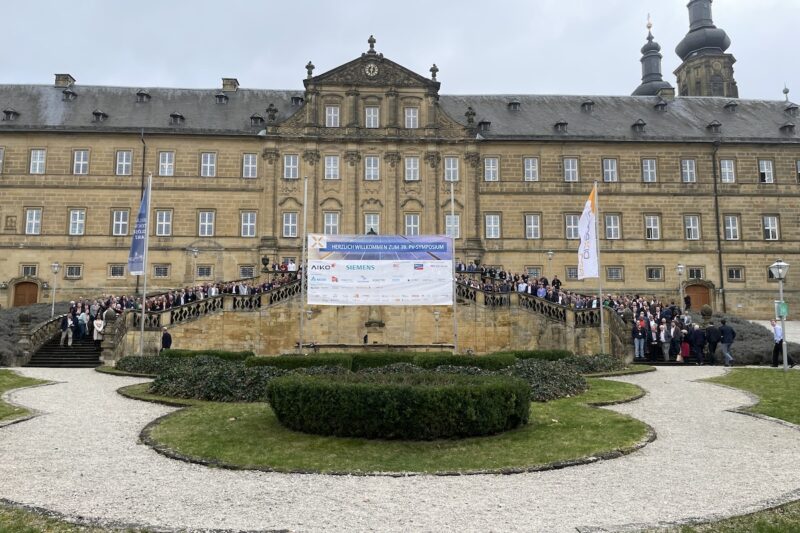 Die Fassade des Klosters Banz (Ort des PV-Sympoiums). Auf einer Freitreppe im mittleren Teil des Bildes haben sich viele Menschen aufgestellt, die Teilnehmerinnen und Teilnehmer.