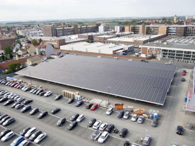 Ein mit einer PV-Anlage teils überdachter Parkplatz eines Unternehmens.