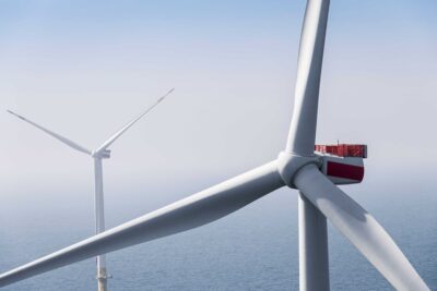 OPffshore-Windturbine auf Nabenhöhe vor zweiter Anlage im Meer.