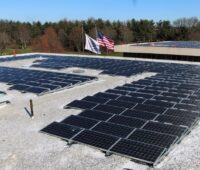 Ein Firmendach ist mit Photovoltaik bestückt. Außerdem weht dort eine kleine US-Flagge.