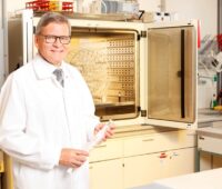 Ein Mann mit weißem Kittel in einem Labor - Entwicklung von Enzymen um Biogas aus organische Restststoffen herzustellen