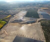 Luftaufnahme des Photovoltaik-Großprojekts in Spanien - man sieht Modulfelder und trockene Landschaft.