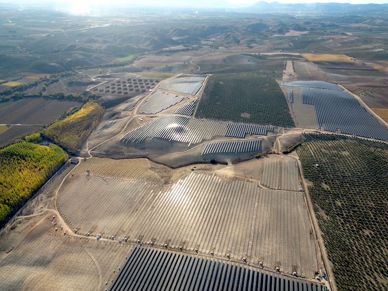 Luftaufnahme des Photovoltaik-Großprojekts in Spanien - man sieht Modulfelder und trockene Landschaft.