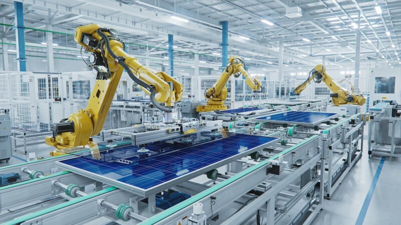 Roboterarm in Photovoltaik-Fabrik - Symbolbild für Solarfabrik, Maschinenbau usw.