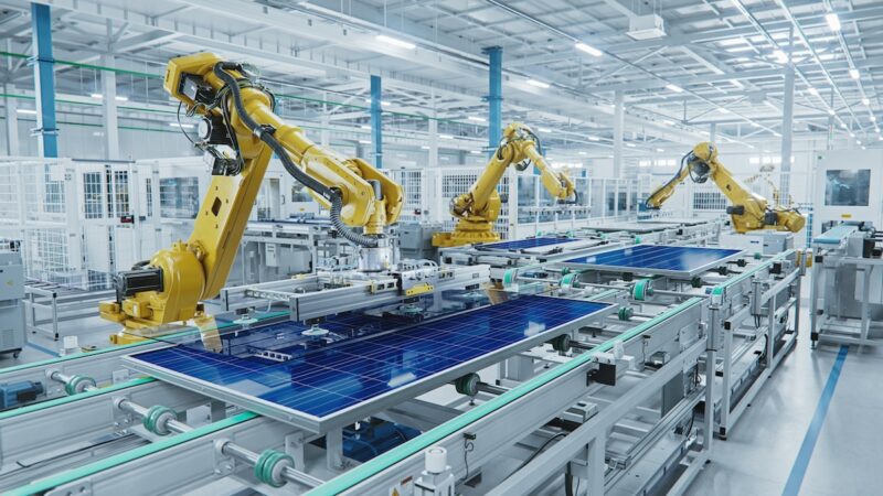 Roboterarme an einer Produktionslinie für Photovoltaik-Module - Symbol für Solarindustrie