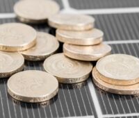 Foto von Photovoltaik-Module mit Münzen - Symbolbild für Direktvermarktung