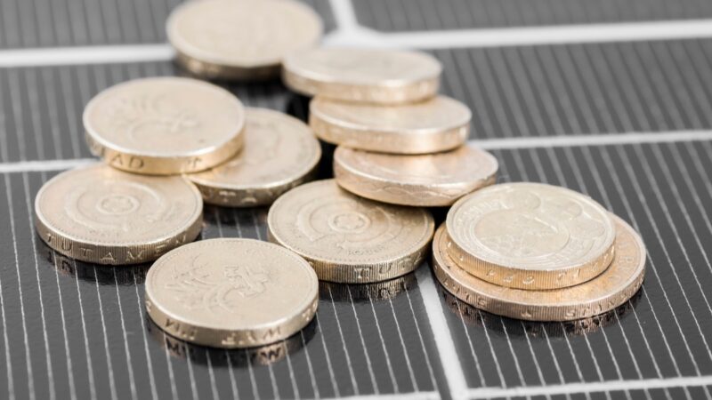 Foto von Photovoltaik-Module mit Münzen - Symbolbild für Direktvermarktung