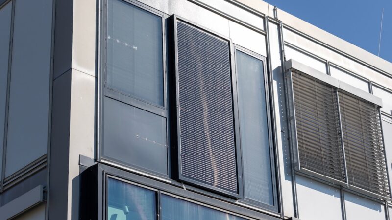EE-Modulfassade: Ein Modul hängt hochkant an einem Bestandsgebäude.