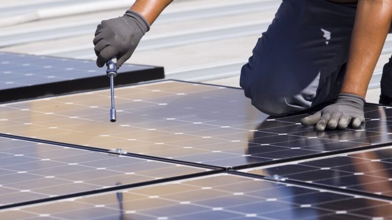 Montieren von Photovoltaik-Modulen auf einem Blechdach - mit der Photovoltaik-Pflicht in Baden-Württemberg wird es viel zu tun geben