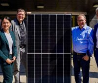 Menschen stehen um ein Photovoltaik-Modul - Startschuss für Solarprogramm für Schulen in Hamburg
