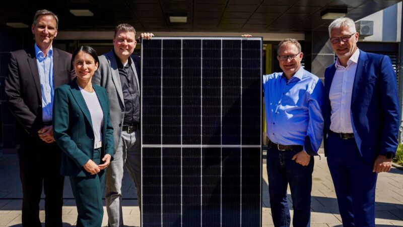 Menschen stehen um ein Photovoltaik-Modul - Startschuss für Solarprogramm für Schulen in Hamburg