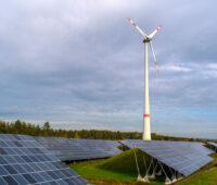 Windkraftanlage hinter einem Solarpark
