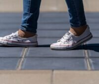 Im Bild ein begehbares Solarpflaster aus Photovoltaik-Modulen, auf dem ein Mensch spaziert, von dem sie Schuhe zu sehen sind.