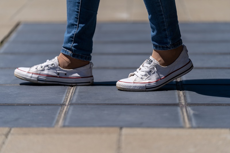 Im Bild ein begehbares Solarpflaster aus Photovoltaik-Modulen, auf dem ein Mensch spaziert, von dem sie Schuhe zu sehen sind.