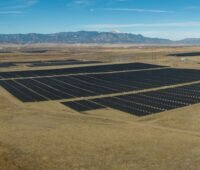 Luftbild von großer Photovoltaik-Anlage in wüster Landschaft.