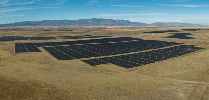 Luftbild von großer Photovoltaik-Anlage in wüster Landschaft.