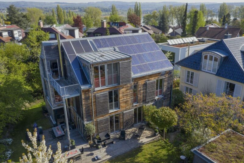 Haus im dörflichen Umfeld mit PV auf den Schrägdächern.
