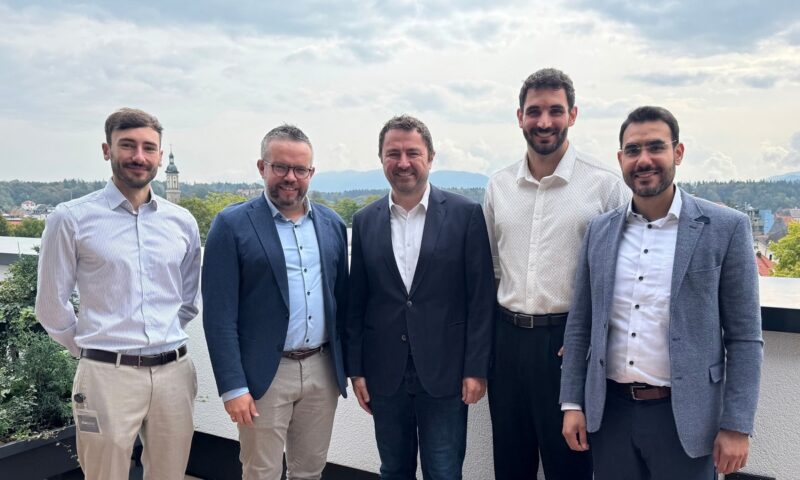 Offizielle auf einem Balkon bei der Vertragsunterzeichnung des Hybrid-PPA für das Photovoltaik-Batteriespeicher-Co-Location-Projekt mit garantiertem Mindesterlös.