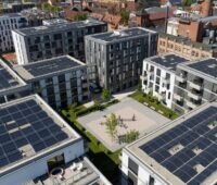 Hochhäuser in der Stadt mit PV-Anlagen auf den Dächern.