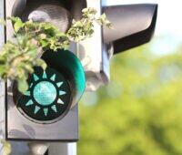 Grüne Ampel mit Sonnensymbol