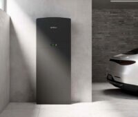 Prolux Storac LFP Batteriespeicher steht in einer sehr aufgräumten Garage mit Elektroauto.