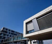 Modernes, quaderförmiges Gebäude vor blauem Himmel: Reiner Lemoine Forschungszentrum bei Q Cells in Thalheim
