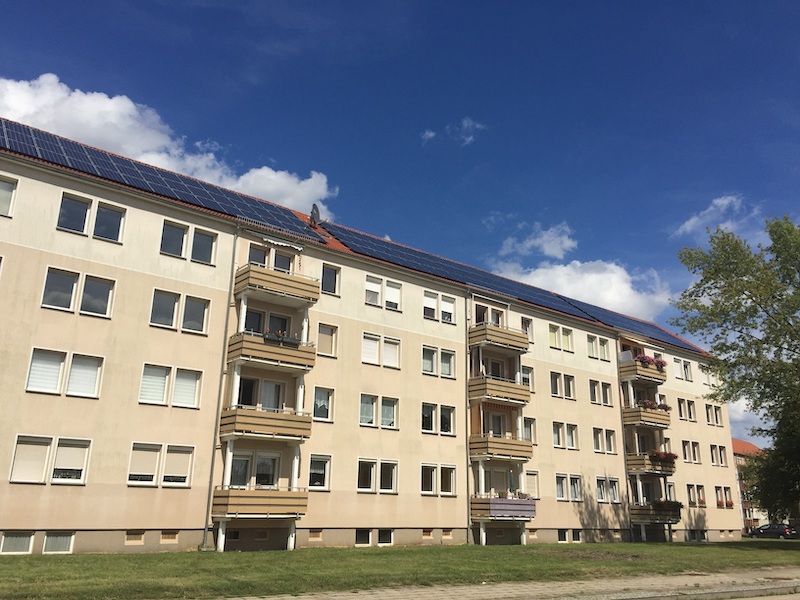 Häuserblock mit Photovoltaik-Anlage auf dem Dach - so sieht Mieterstrom aus.