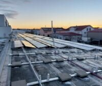 Auf dem Flachdach eines Produktionsbetriebs entsteht eine PV-Anlage.