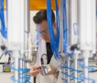 Zu sehen ist ein Mitarbeiter von Q Cells in der Qualitätskontrolle. Das Prüfsiegel „Quality Controlled PV“ ist besonders streng.