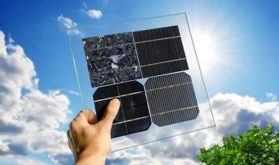 Im Bild eine Hand, die Silizium-basierte Solarzellen in die Sonne hält, vom Perowskit-Tandemzellen verspricht sich Qcelle einen höheren Wirkungsgrad.