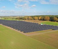 Eine Freiflächen-PV-Park auf einer grünen Wiese.