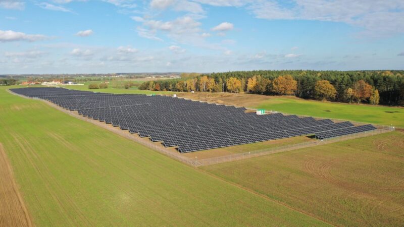 Eine Freiflächen-PV-Park auf einer grünen Wiese.