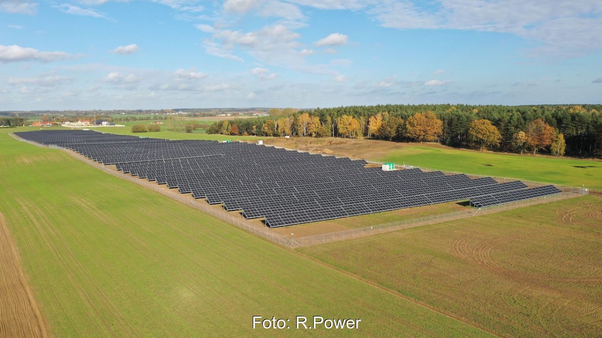 Eine Freiflächen-PV-Park auf einer grünen Wiese.