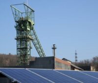 Vor einem Förderturm für Kohle ist ein Solardach installiert