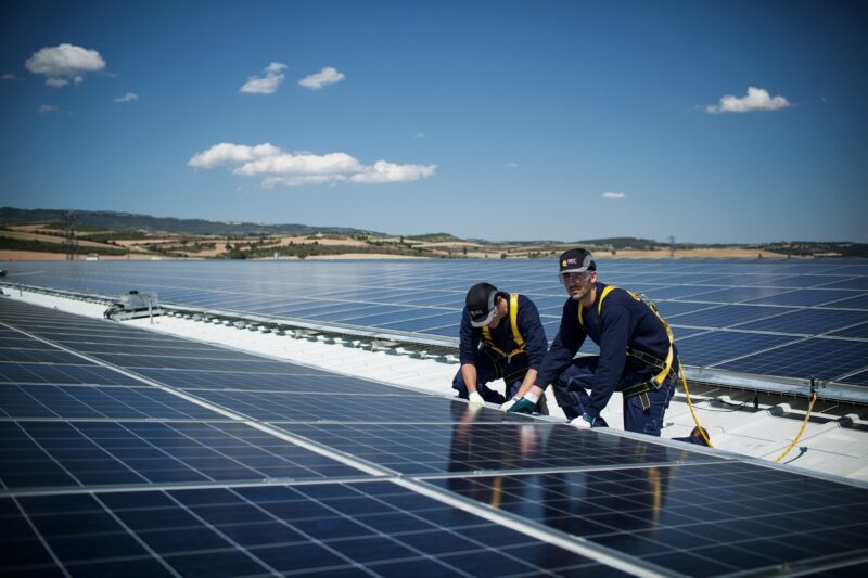 Zu sehen sind Arbeiter auf dem Dach. Es handelt sich um eine der 10 GW installierte Photovoltaik-Leistung von REC.