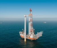 Installation einer Windenergieanlage mit Kranschiff auf dem Meer.