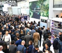 Eine große Menschenmenge besucht einen Messestand des Batterieherstellers CATL auf einer Energiefachmesse. Die Besucherinnen und Besucher stehen dicht gedrängt vor einer Präsentationsfläche mit einer großen Videowand.