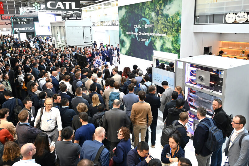 Eine große Menschenmenge besucht einen Messestand des Batterieherstellers CATL auf einer Energiefachmesse. Die Besucherinnen und Besucher stehen dicht gedrängt vor einer Präsentationsfläche mit einer großen Videowand.