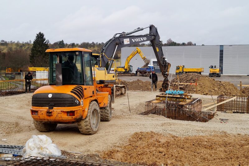 Zu sehen ist ein Bagger auf der Baustelle für die Heizzentrale, in die die größte Solarthermie-Dachanlage Deutschlands die Wärme einspeisen soll.