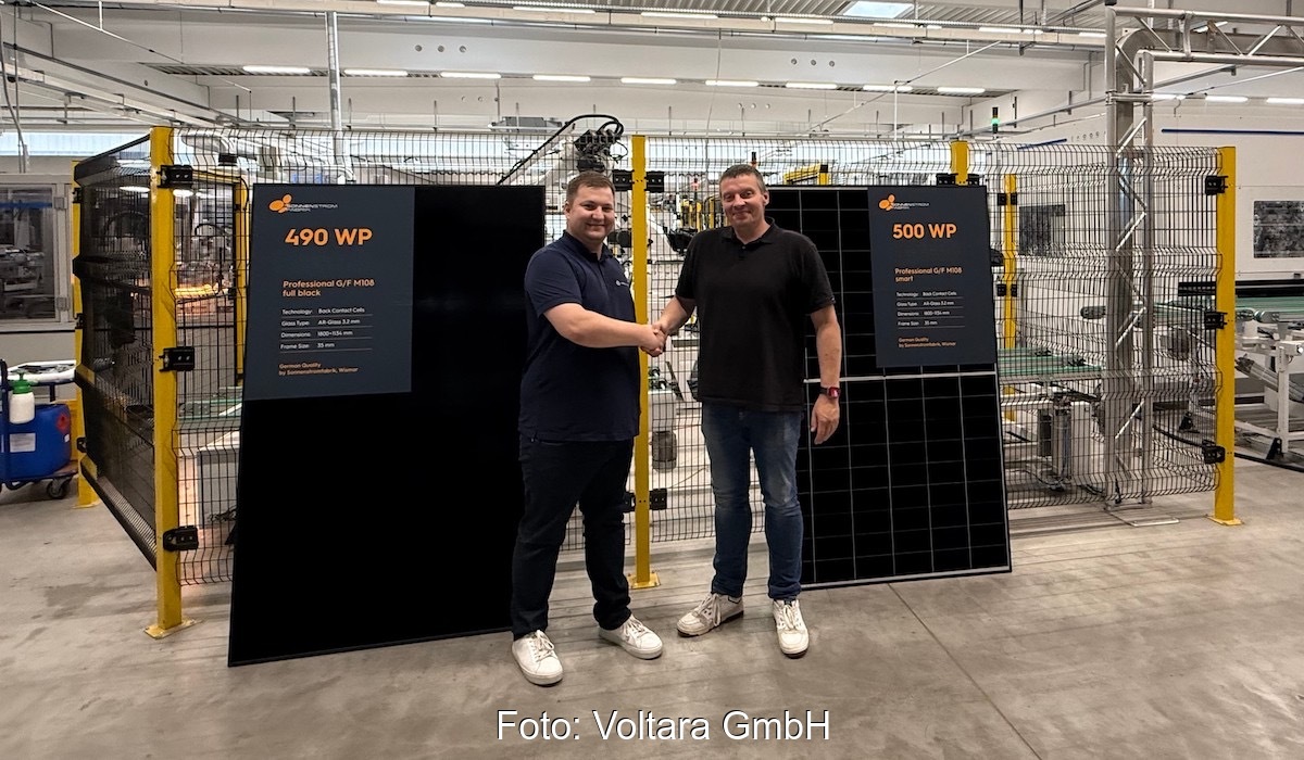 Die beiden Verantwortlichen stehen händeschüttelnd in der Produktionshalle für 500-W-Back-Contact-Module bei Sonnenfarbrik.