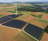 Luftbild eines Solarparkes nebst Windanlagen.