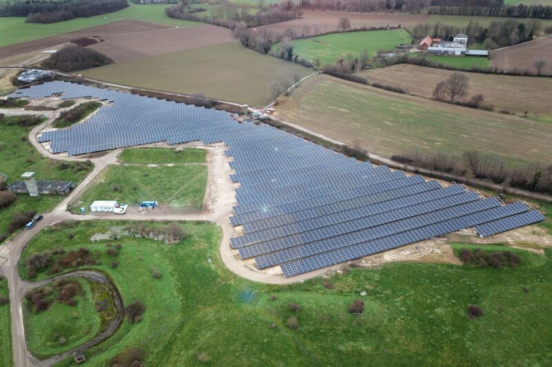 Luftbild einer Freiflächen-Solaranlage auf flachem Terrain.