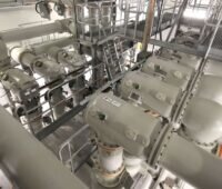Blick in eine gasisolierte 420-kV-Schaltanlage mit großformatigen gekapselten Hochspannungskomponenten und Wartungsstegen.