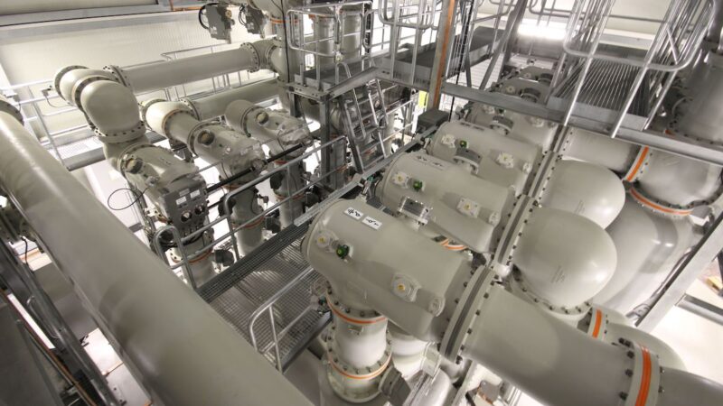 Blick in eine gasisolierte 420-kV-Schaltanlage mit großformatigen gekapselten Hochspannungskomponenten und Wartungsstegen.