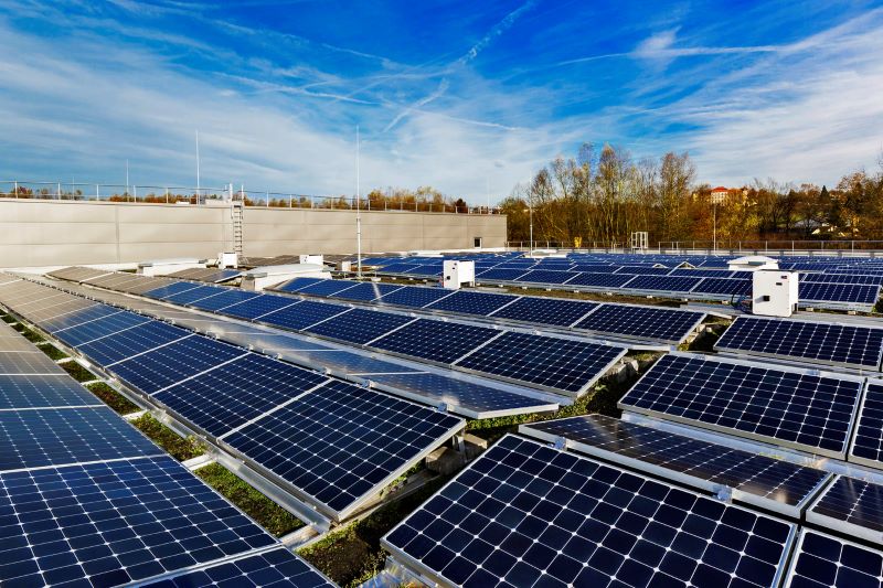 Blick auf eine Dach mit Solarmodulen und Wechselrichterboxen.