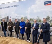 Im Bild ist eine Reihe von Menschen aus Politik und von SMA mit einem Spaten in der Hand als symbolischen Spatenstich für die SMA Gigawatt-Factory.