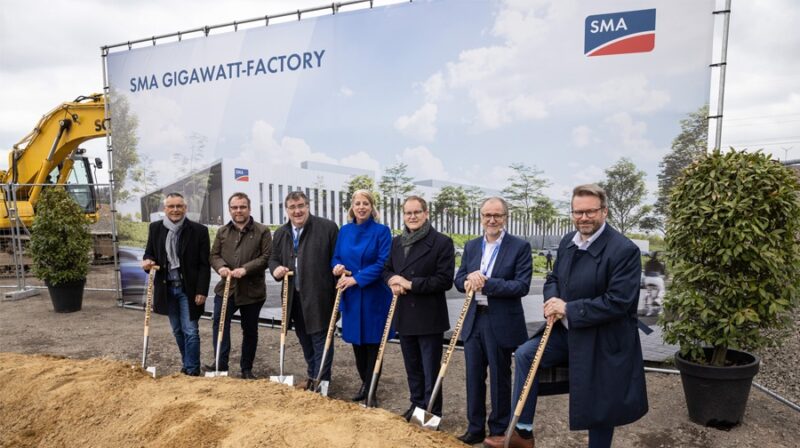 Im Bild ist eine Reihe von Menschen aus Politik und von SMA mit einem Spaten in der Hand als symbolischen Spatenstich für die SMA Gigawatt-Factory.