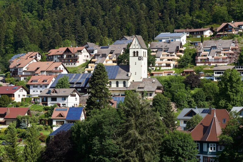 ZU sehen ist ein idyllisches Dorf mit vielen Photovoltaik-Anlagen, die für das Energiemanagement für die Bürgerenergiewende geeignet sind.